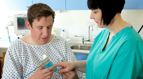 Image of patient and nurse in endoscopy ward. Nurse showing how to use a demand valve